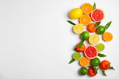 Photo of Different citrus fruits on white background, top view. Space for text