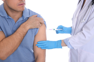 Doctor giving injection to patient on white background, closeup. Vaccination concept