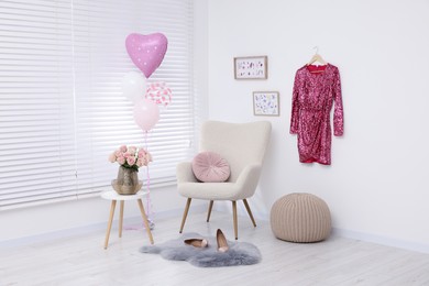 Photo of Shiny glitter dress, beautiful roses on coffee table and air balloons in cozy room. Preparing for birthday party
