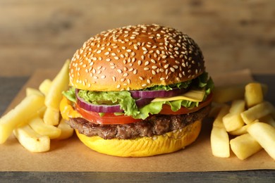 Photo of Burger with delicious patty and french fries on table, closeup