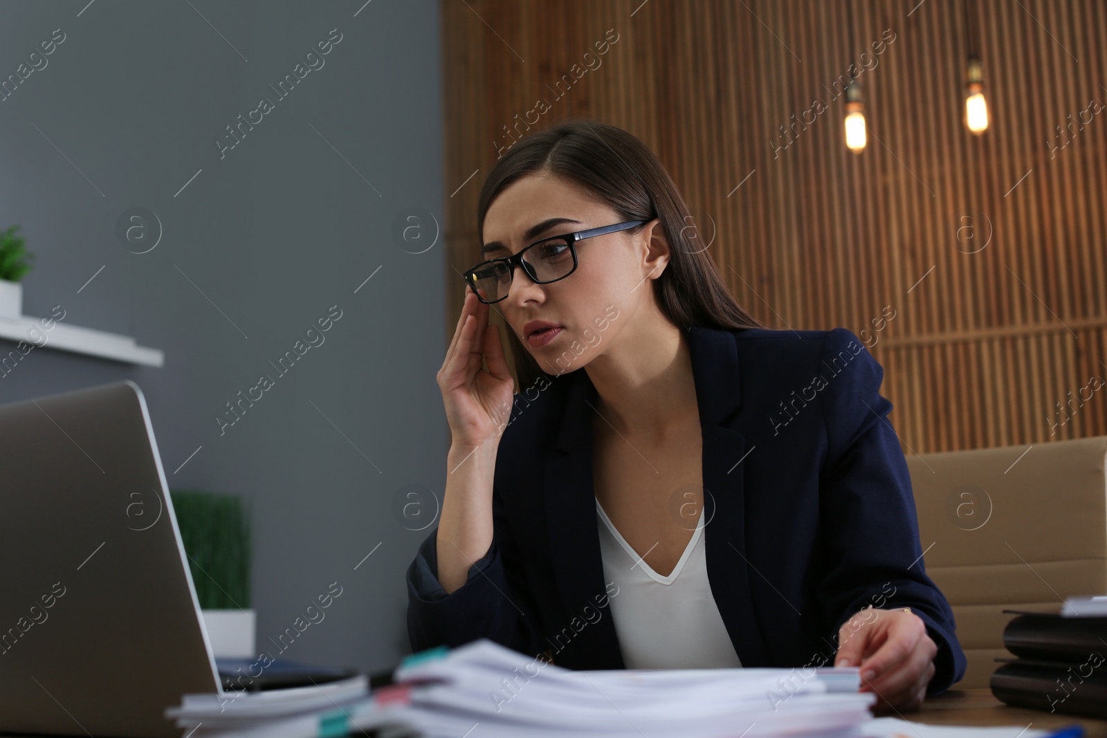 Photo of Businesswoman working with laptop and documents at table in office