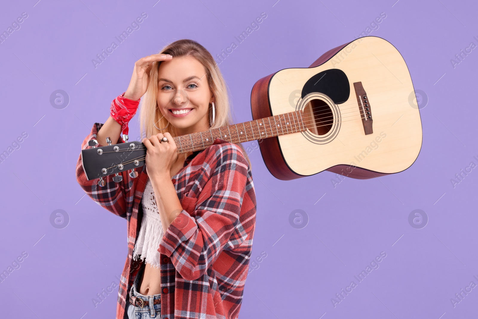 Photo of Happy hippie woman with guitar on purple background