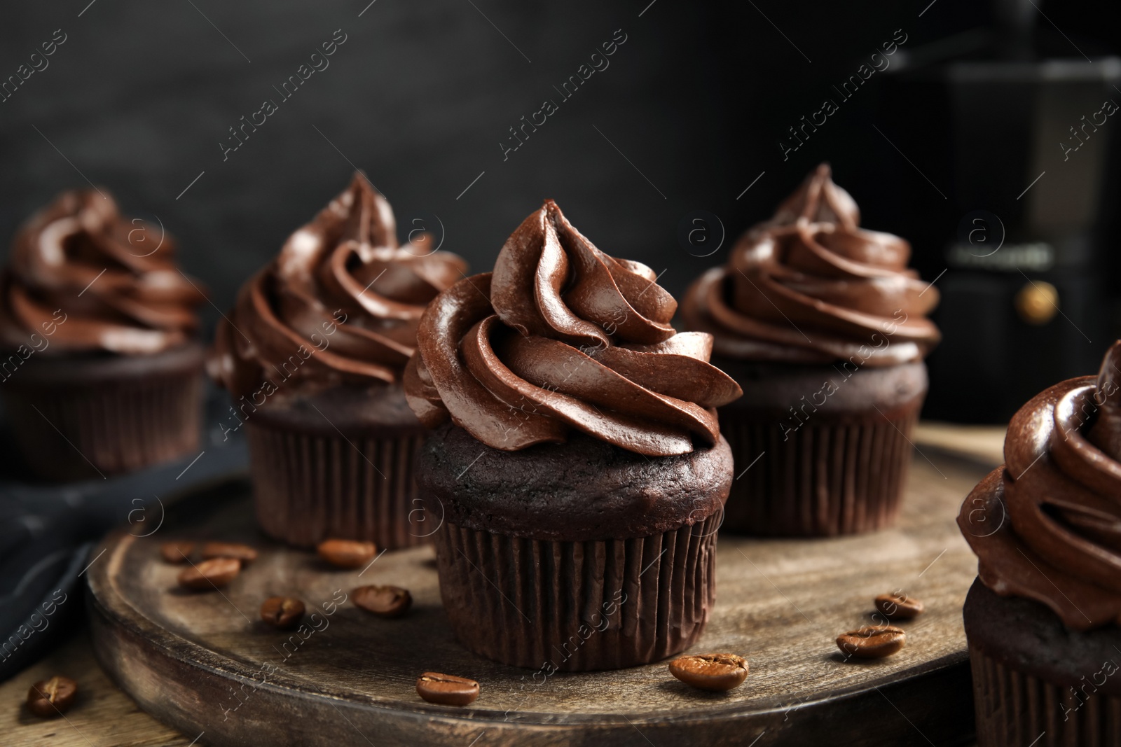 Photo of Delicious chocolate cupcakes with cream on wooden table