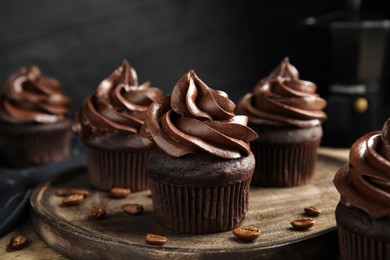 Delicious chocolate cupcakes with cream on wooden table