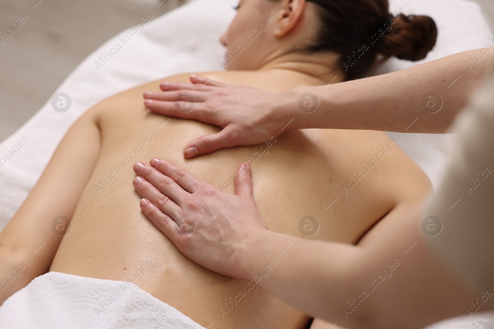 Photo of Woman receiving back massage on couch in spa salon, closeup