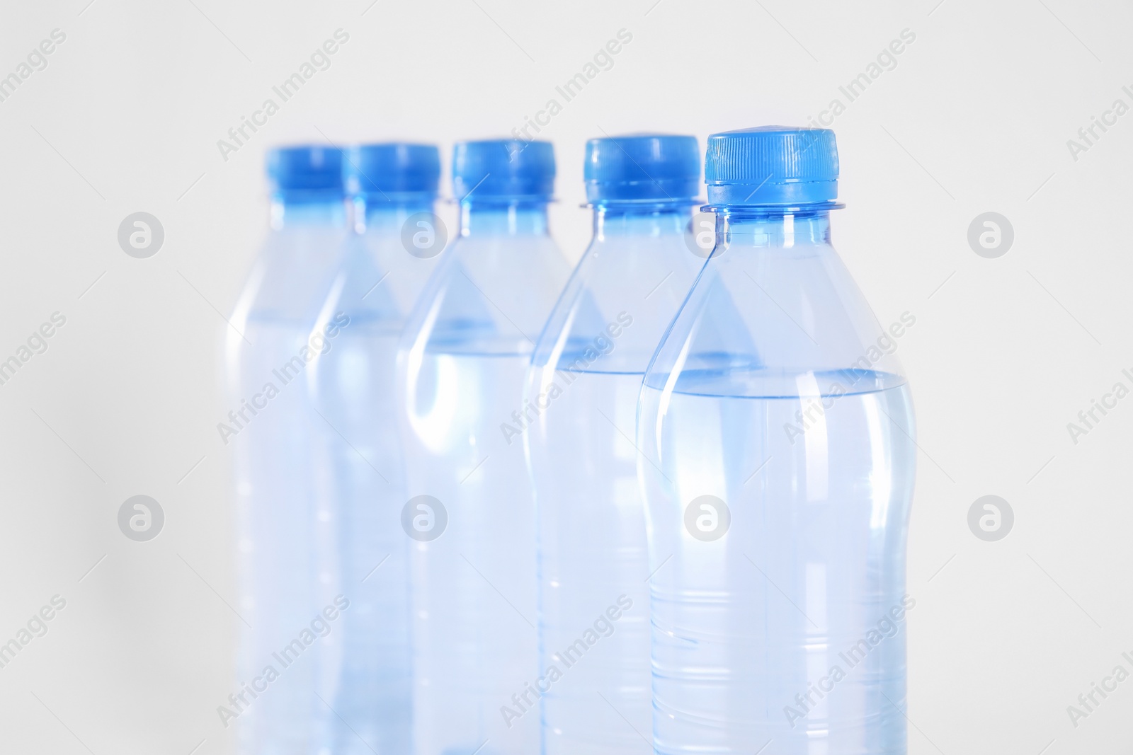 Photo of Plastic bottles with pure water on white background, closeup