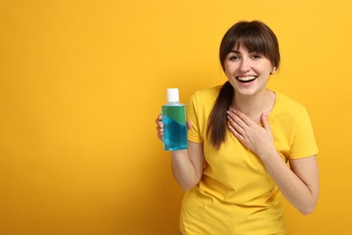 Photo of Young woman with mouthwash on yellow background, space for text