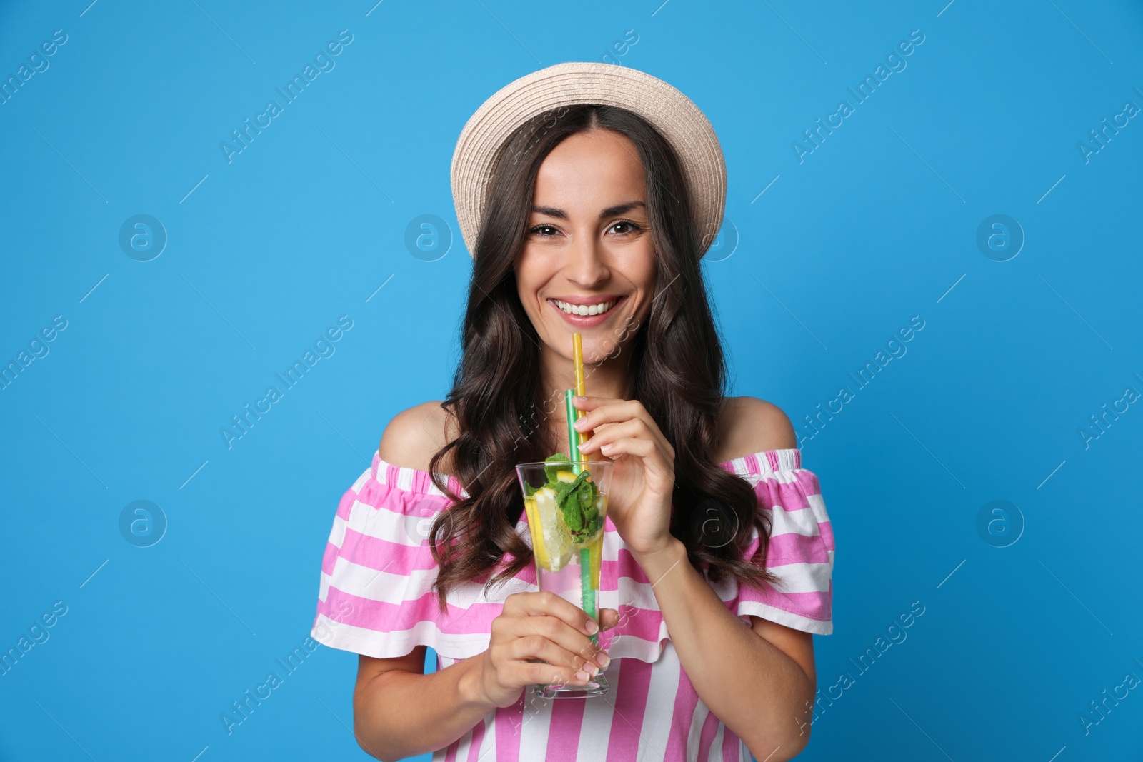 Photo of Young woman with refreshing drink on blue background