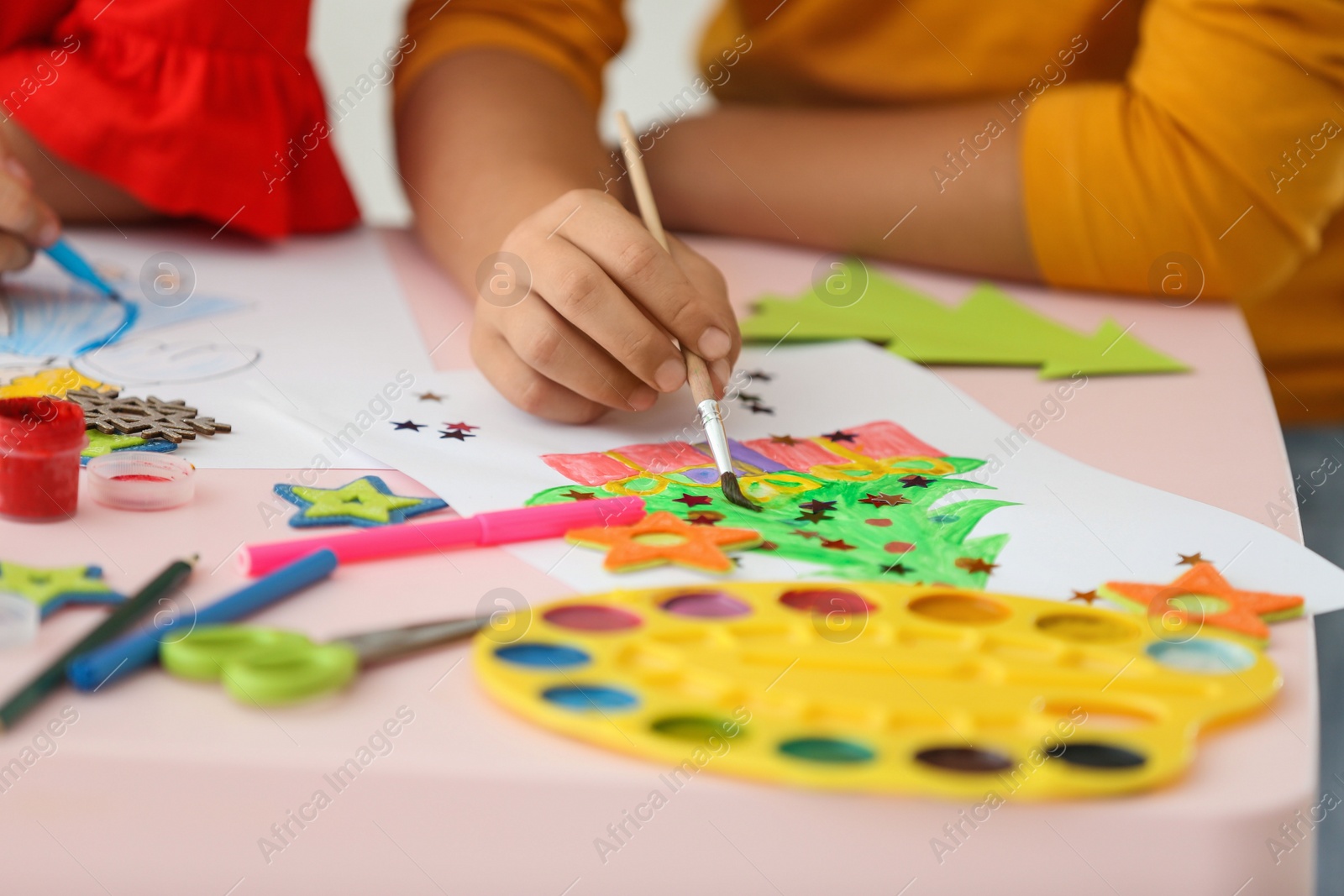 Photo of Little children drawing at table indoors, closeup. Christmas season