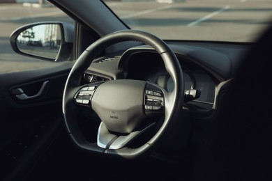 Photo of Black steering wheel inside of modern car