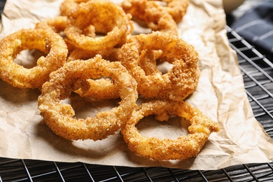 Photo of Cooling rack with homemade crunchy fried onion rings, closeup