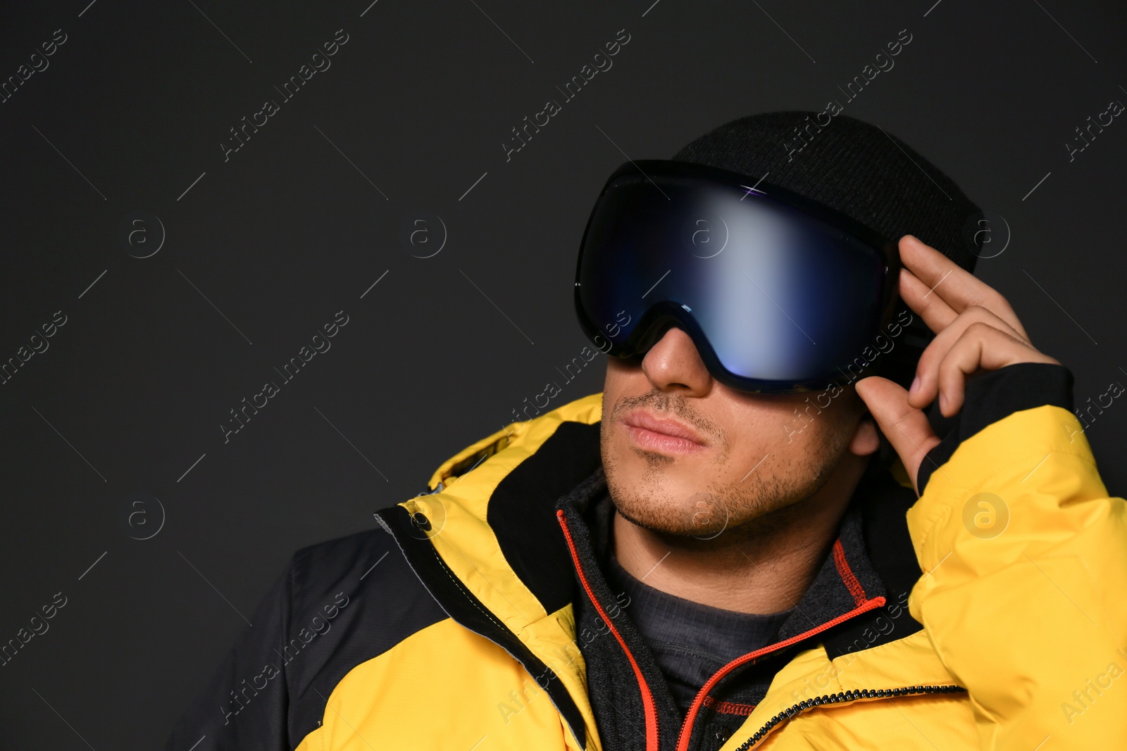 Photo of Man wearing stylish winter sport clothes on black background