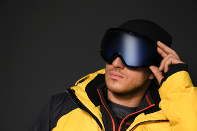 Photo of Man wearing stylish winter sport clothes on black background