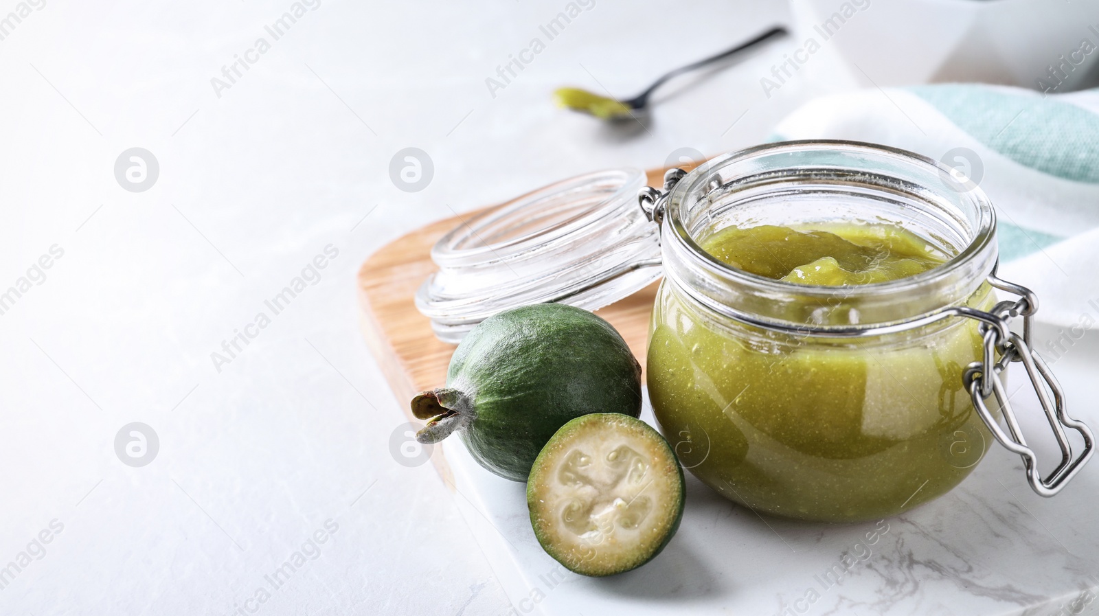 Image of Feijoa jam and fresh fruits on white table, space for text. Banner design