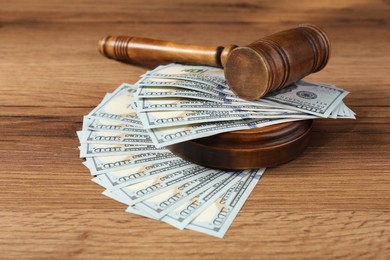 Judge's gavel and money on wooden table