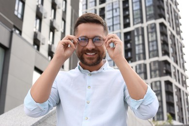 Photo of Portrait of handsome bearded man in glasses outdoors