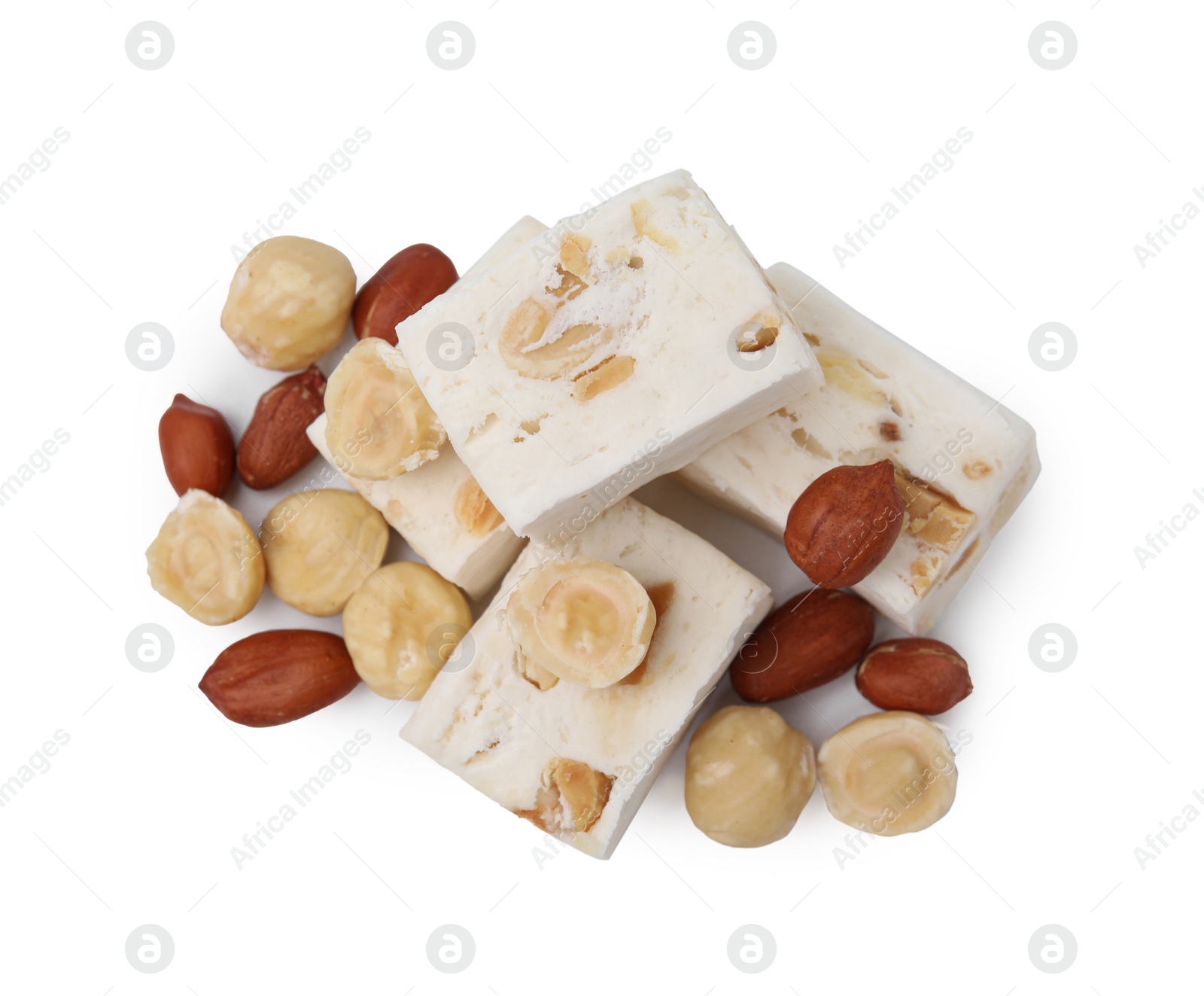 Photo of Pieces of delicious nougat and nuts on white background, top view