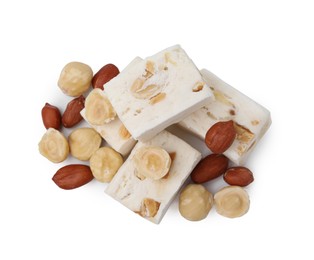 Photo of Pieces of delicious nougat and nuts on white background, top view