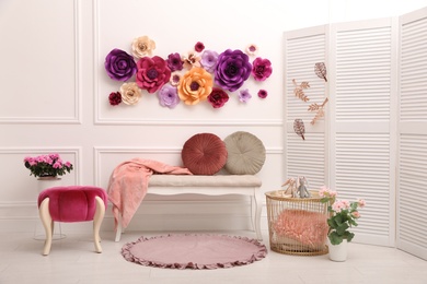 Photo of Elegant Easter photo zone with paper flowers and bench indoors