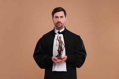 Photo of Judge with figure of Lady Justice on light brown background