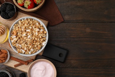 Photo of Tasty granola, yogurt and fresh berries served on wooden table, flat lay with space for text. Healthy breakfast