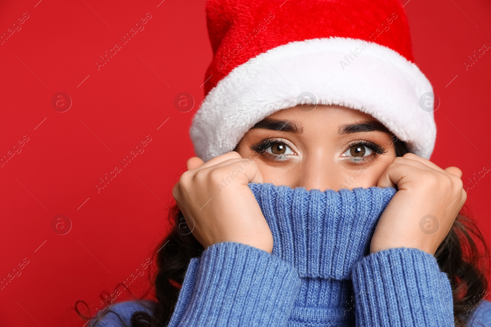 Photo of Beautiful woman in Santa hat on red background. Christmas party