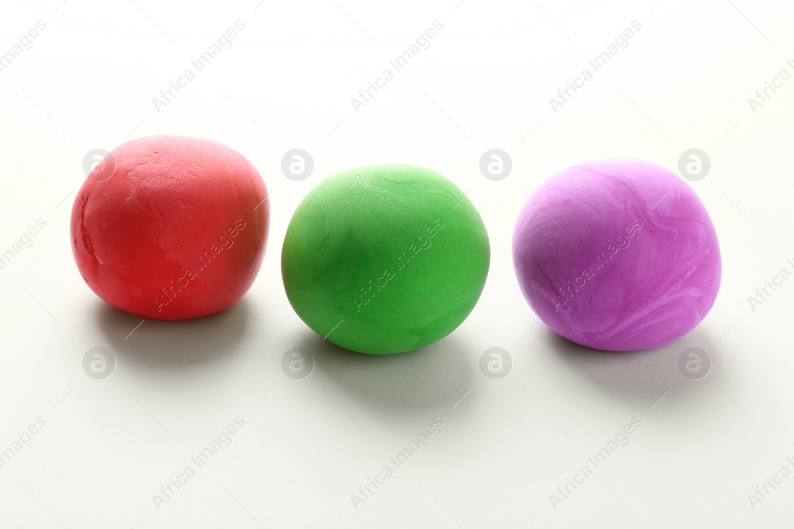 Photo of Different color play dough balls on white background