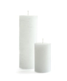 Different pillar wax candles on white background