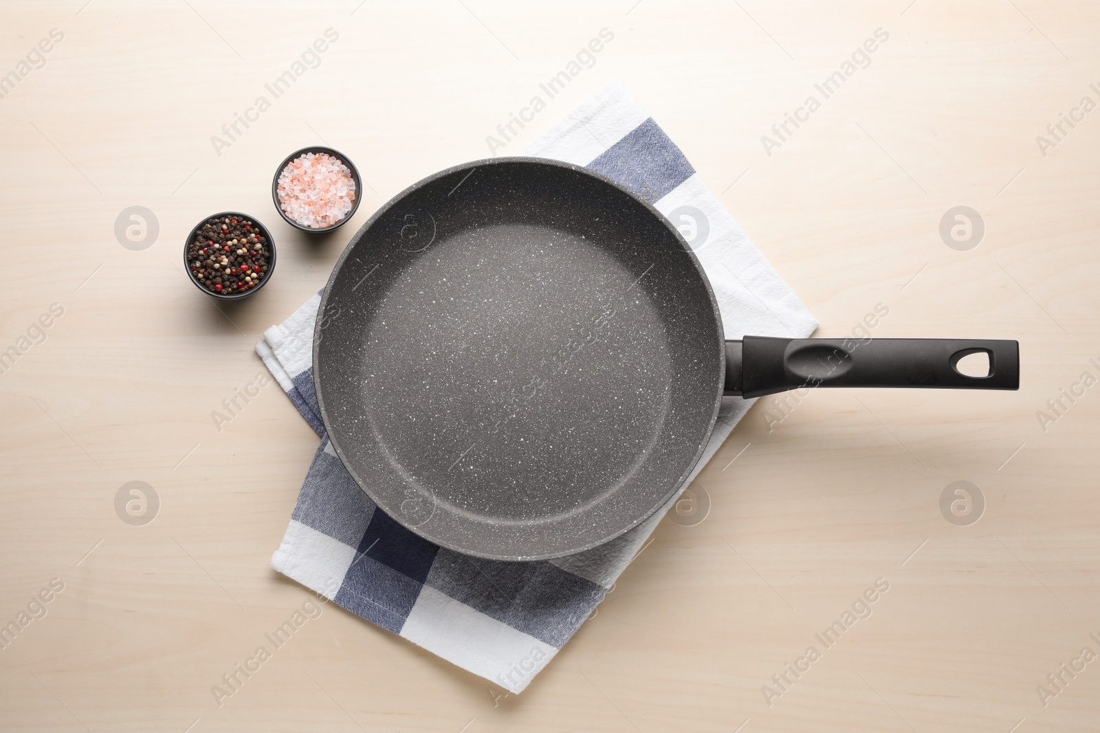 Photo of Empty frying pan, himalayan salt and peppercorn mix on wooden table, flat lay