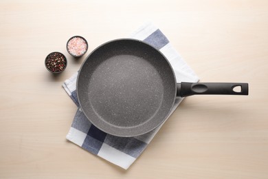 Empty frying pan, himalayan salt and peppercorn mix on wooden table, flat lay