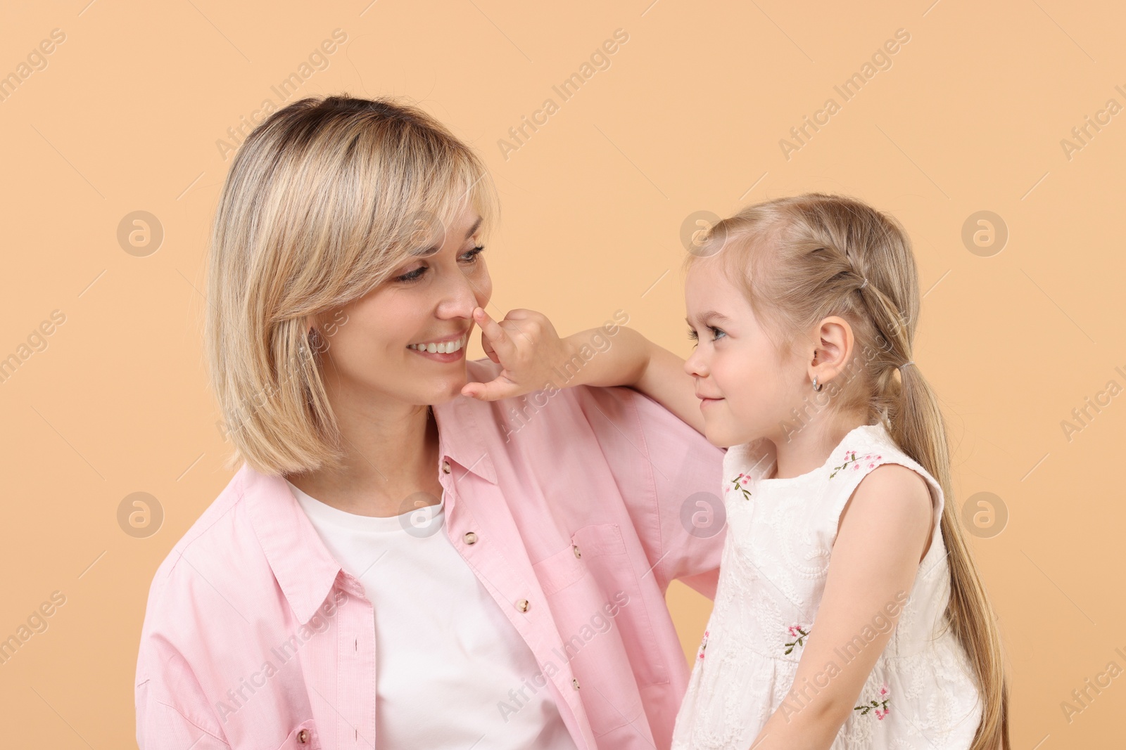 Photo of Family portrait of happy mother and daughter on beige background