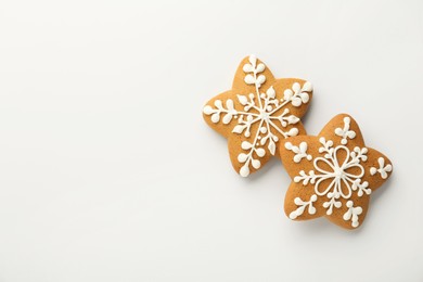 Tasty Christmas cookies with icing on white background, flat lay. Space for text