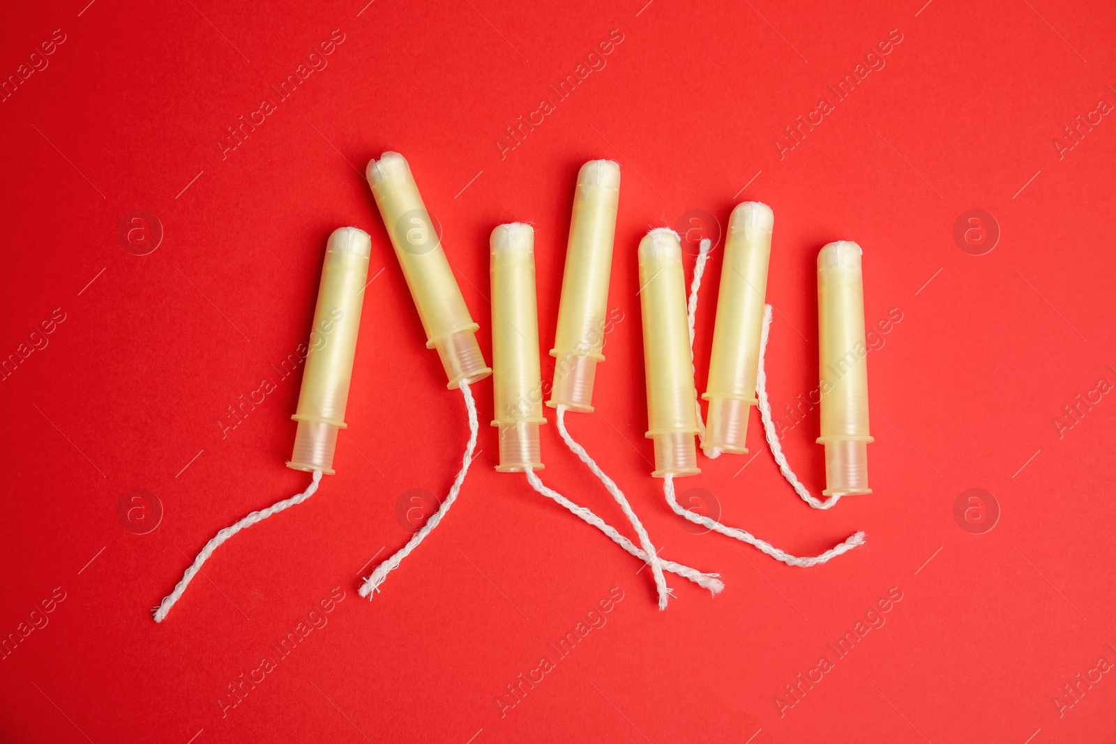 Photo of Tampons on red background, flat lay. Menstrual hygiene product