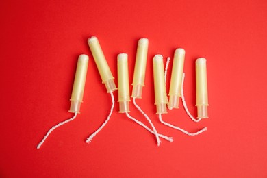 Photo of Tampons on red background, flat lay. Menstrual hygiene product