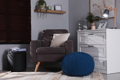 Photo of Stylish different poufs and armchair in room. Home design