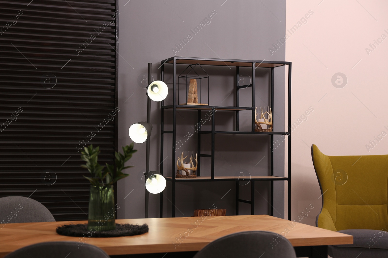 Photo of Stylish room interior with shelving unit grey wall. Modern design