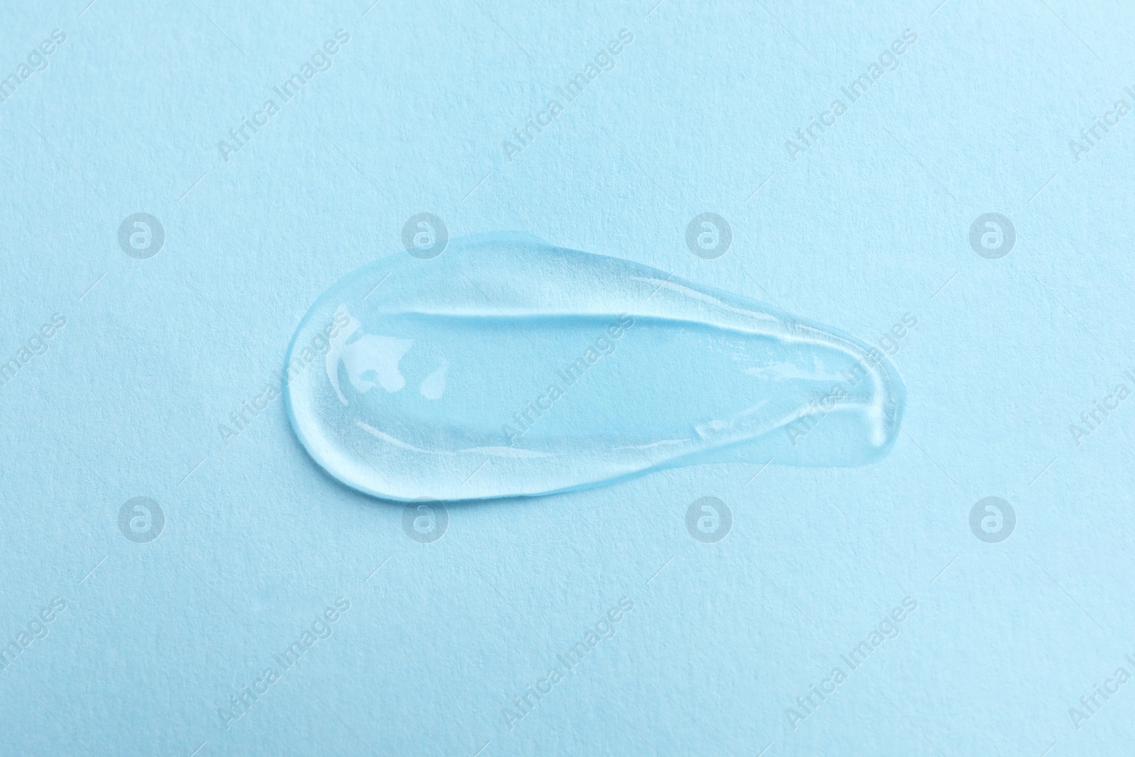 Photo of Swatch of cosmetic gel on light blue background, top view