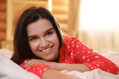 Photo of Young woman lying in bed at home. Lazy morning
