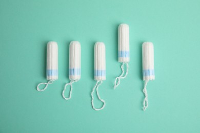 Tampons on turquoise background, flat lay. Menstrual hygiene product