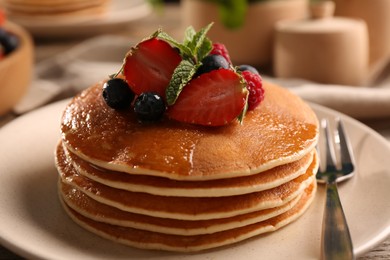 Photo of Tasty pancakes with fresh berries and mint on table, closeup