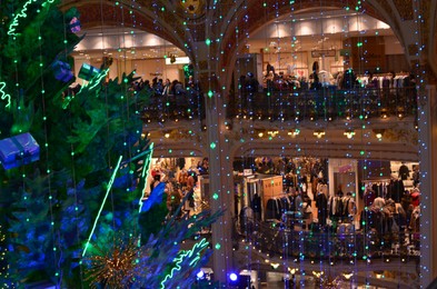 Paris, France - December 10, 2022: Crowded Galeries Lafayette Haussmann with beautiful Christmas decor