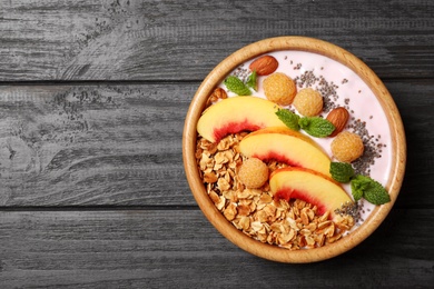 Healthy homemade granola with yogurt on grey wooden table, top view. Space for text
