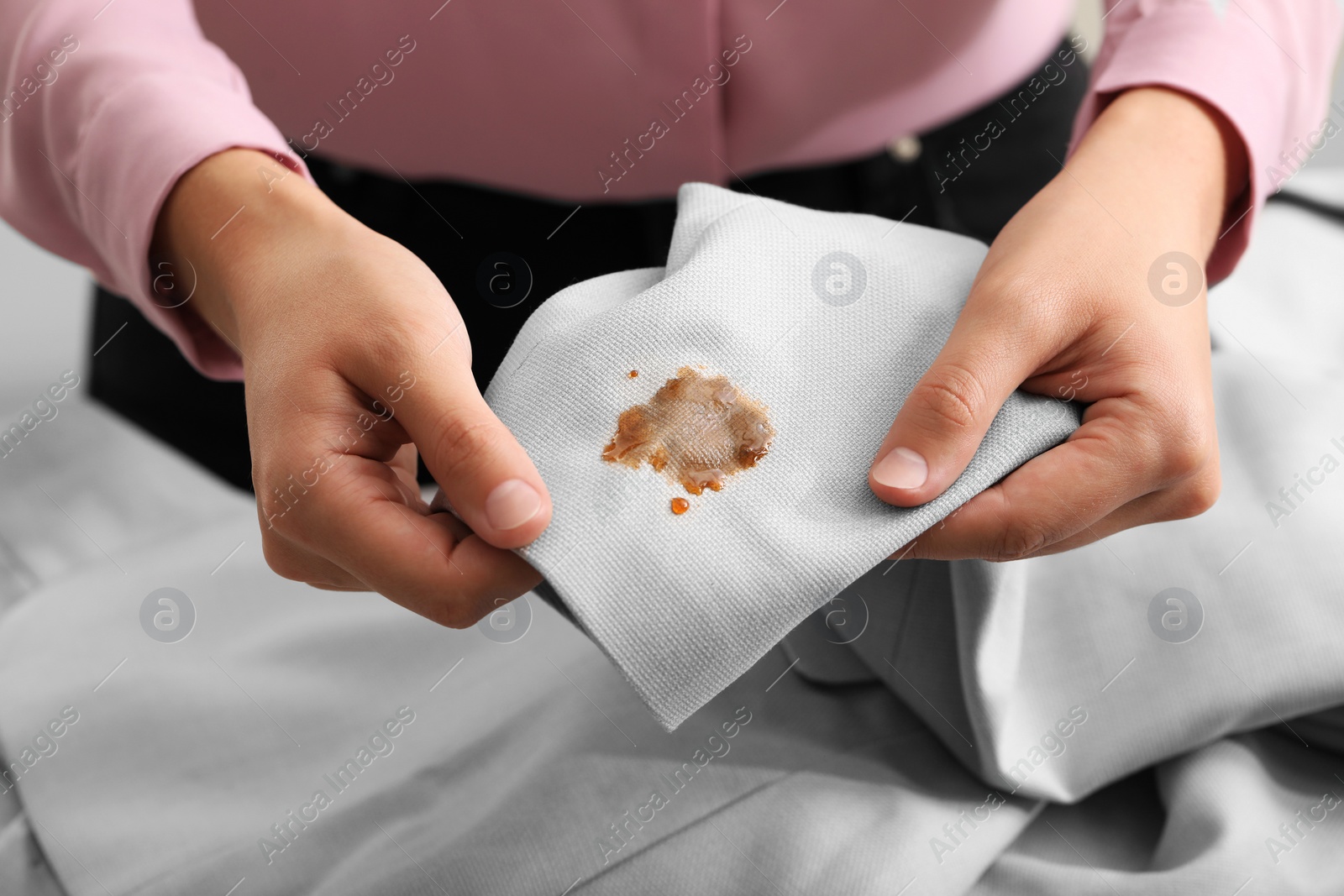 Photo of Woman showing jacket with stain of coffee, closeup