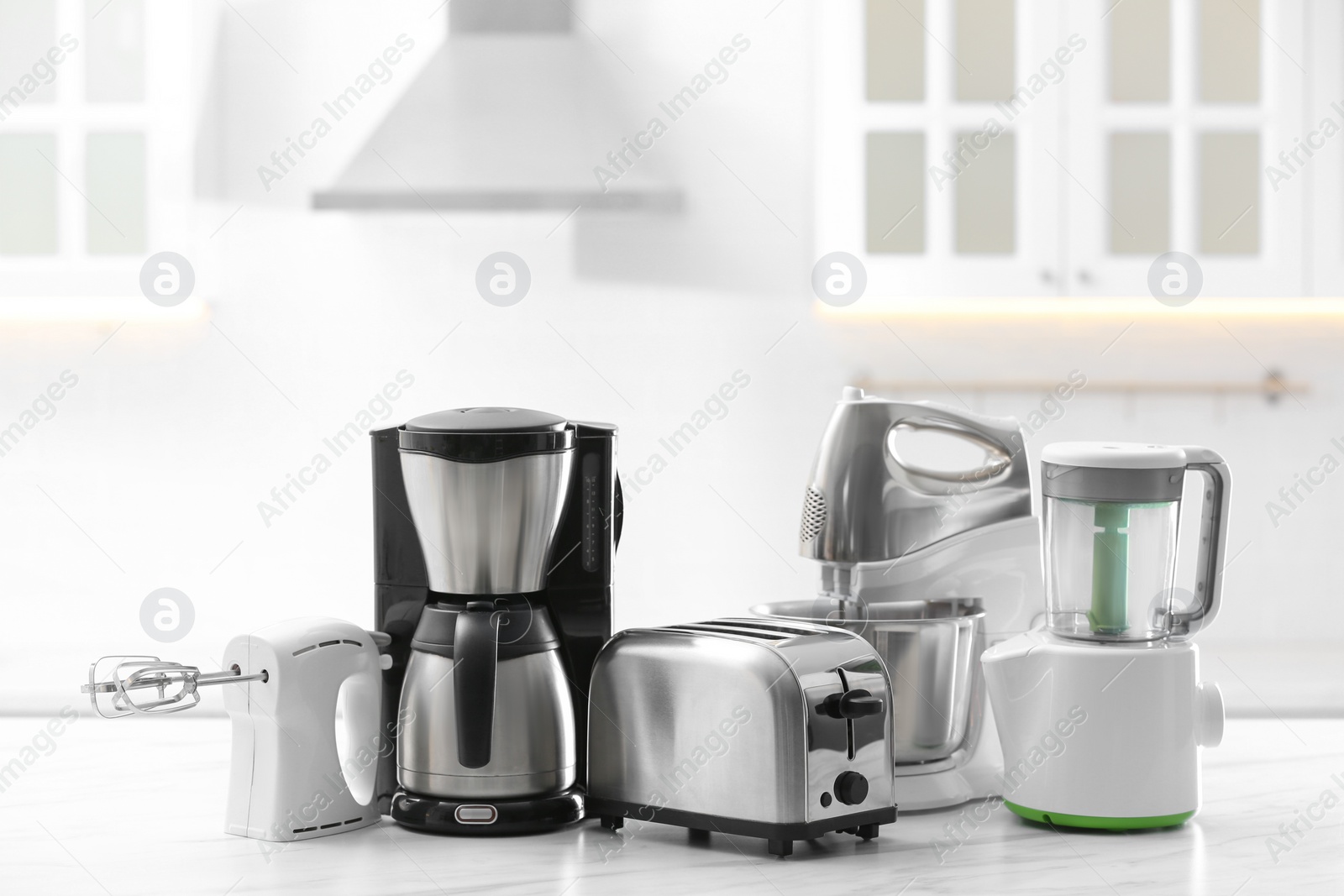 Photo of Modern toaster and other cooking appliances on table in kitchen