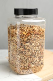Photo of Jar with dried orange zest seasoning on board