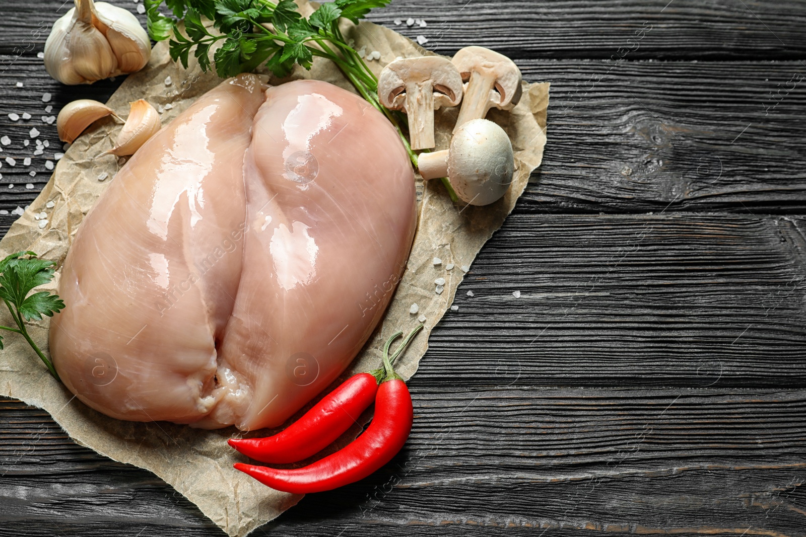 Photo of Composition with raw chicken breasts and space for text on wooden background