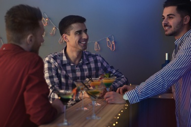 Photo of Young men with martini cocktails at party