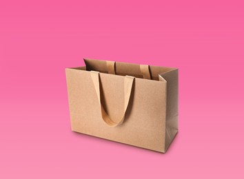 Kraft paper shopping bag on pink background