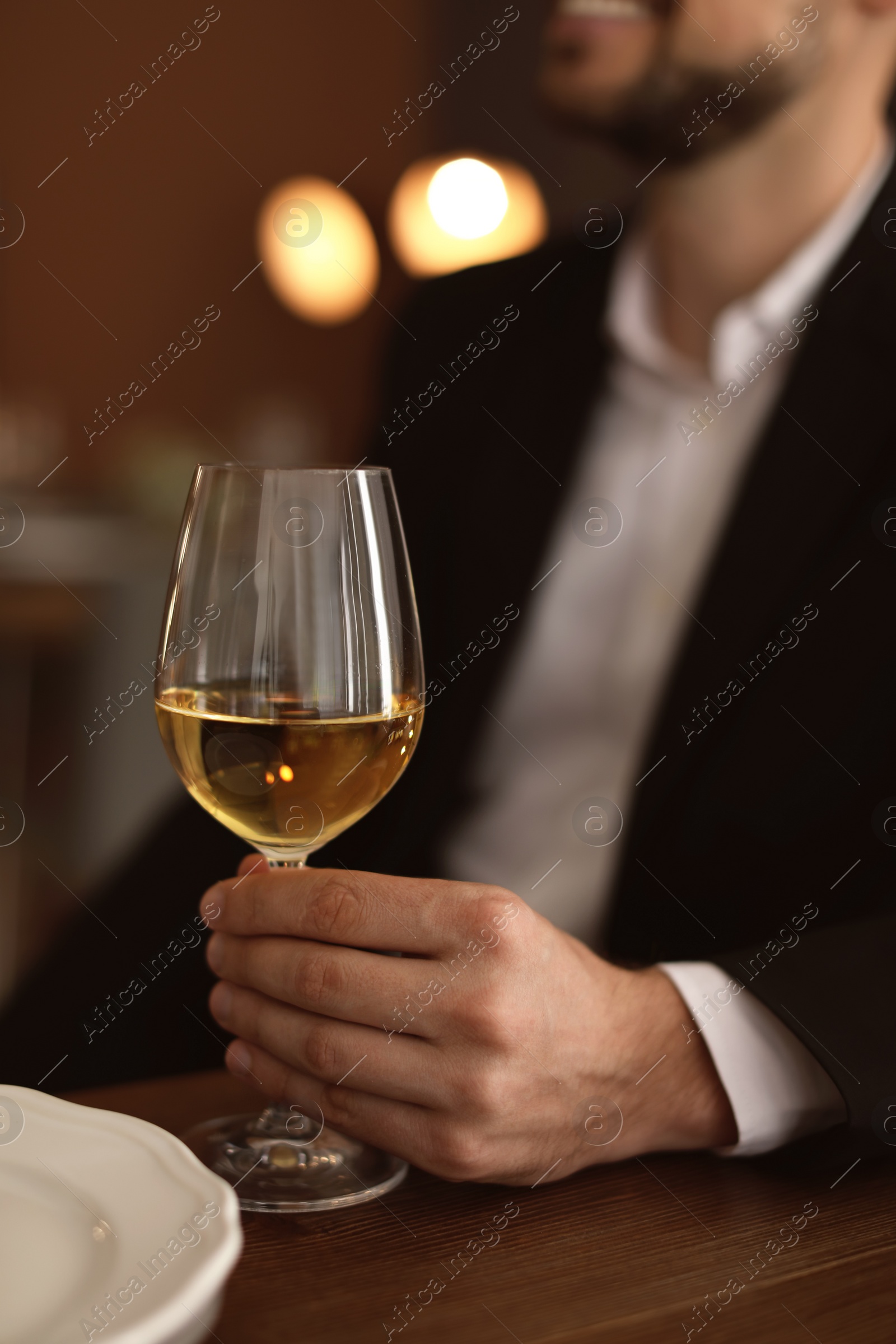 Photo of Man with glass of wine at table in restaurant