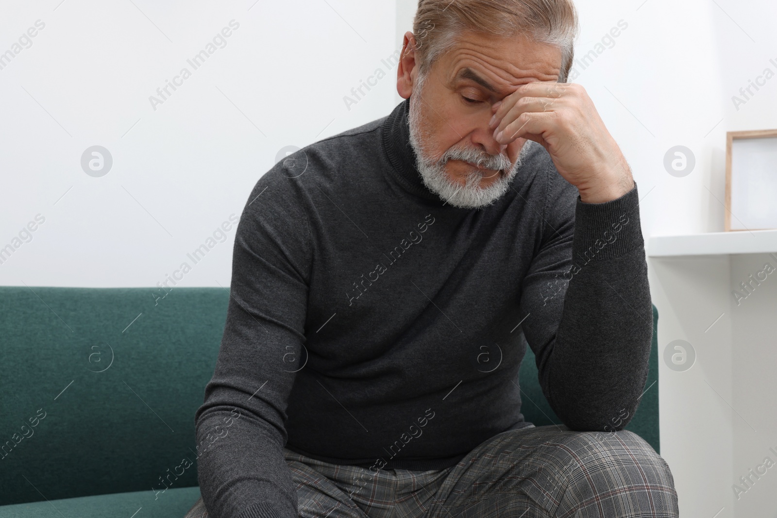 Photo of Upset senior man on sofa at home. Loneliness concept